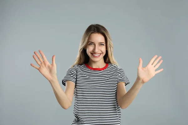 Γυναίκα Δείχνει Νούμερο Δέκα Χέρια Της Ανοιχτό Γκρι Φόντο — Φωτογραφία Αρχείου