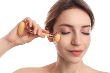 Beyaz arka planda doğal yeşim taşı kullanan genç bir kadın, yakın plan.