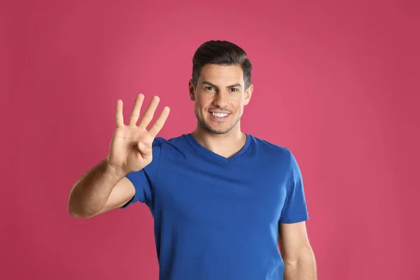 Άνθρωπος Που Δείχνει Νούμερο Τέσσερα Χέρι Του Ροζ Φόντο — Φωτογραφία Αρχείου