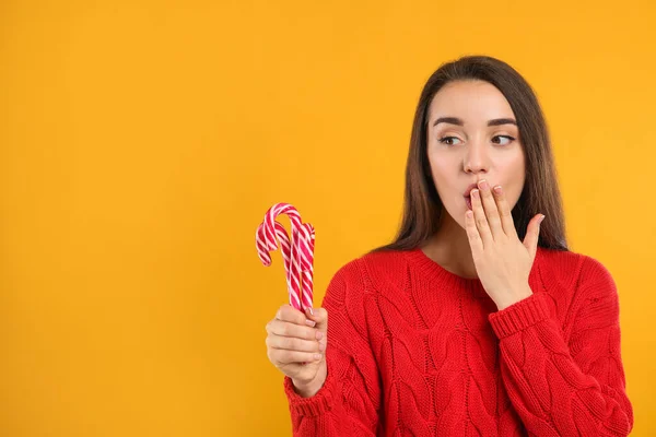 Young Woman Red Sweater Holding Candy Canes Yellow Background Space — Stock Photo, Image