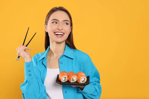 Jovem Feliz Com Prato Rolos Sushi Pauzinhos Fundo Laranja Espaço — Fotografia de Stock