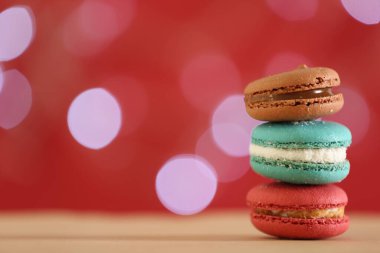 Delicious macarons on table against blurred background, closeup. Space for text