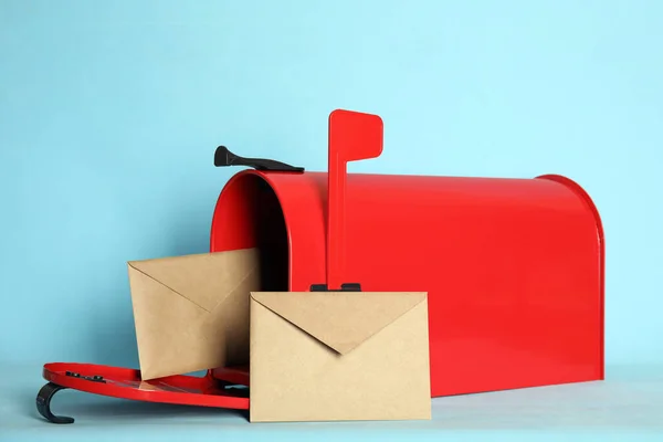 Open red letter box with envelopes on turquoise background