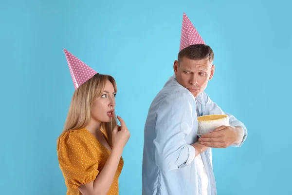 스러운 남자가 청록색 배경에 여자한테 케이크를 숨기고 — 스톡 사진