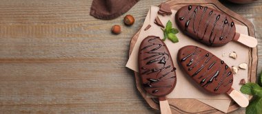 Lezzetli jöleli dondurmalar, fındıklar ve nane şekeri ahşap masa üzerinde, düzlük ve yazı için yer. Pankart tasarımı