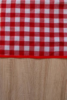 Ahşap masanın üzerinde kareli piknik örtüsü, üst manzara. Metin için boşluk