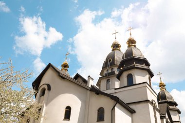 Bulutlu gökyüzüne karşı altın kubbeleri olan güzel kilise