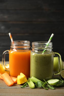 Lezzetli sebze suları ve ahşap masada taze malzemeler.