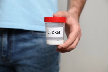 Bej arka planda spermi olan donör kutusu, yakın plan.