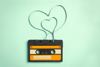 Müzik kaseti ve turkuaz arka planda bant ile yapılmış kalpler, üst manzara. Aşk şarkısını dinlerken