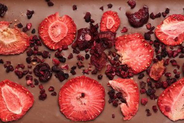 Arka plan olarak dondurulmuş çilek ve kirazlı çikolata, yakın plan.