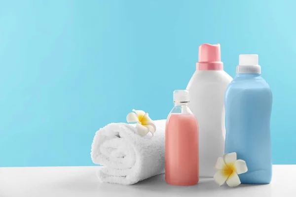 Μπουκάλια Απορρυπαντικά Πλυντηρίων Πετσέτες Και Λουλούδια Plumeria Λευκό Τραπέζι Χώρος — Φωτογραφία Αρχείου