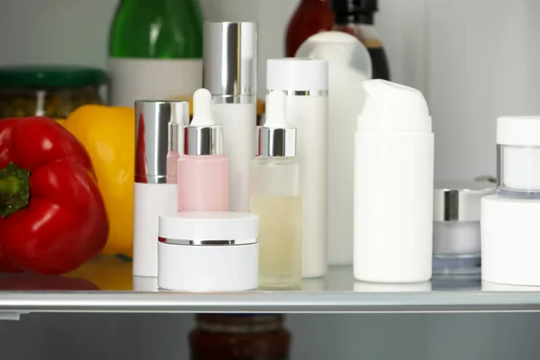 Different cosmetic products on shelf in refrigerator