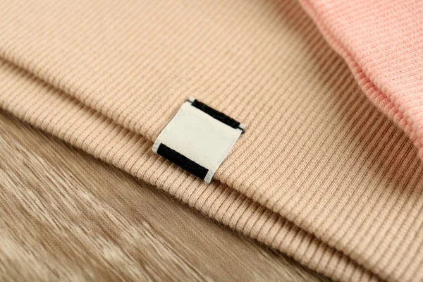 Abbigliamento Beige Con Etichetta Abbigliamento Bianco Sul Tavolo Legno Primo — Foto Stock
