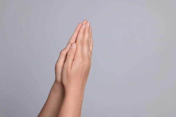 Woman Holding Hands Clasped While Praying Light Grey Background Closeup — Stock Photo, Image