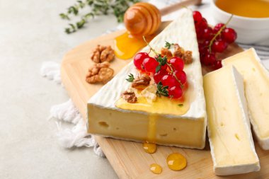 Krem peyniri kırmızı frenk üzümü, ceviz ve bal ile servis edilir.