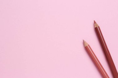 Pembe arka planda dudak kalemi, metin için boşluk. Kozmetik ürünü