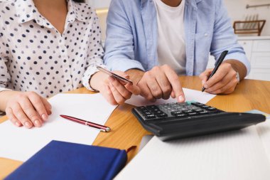 Genç çift mutfakta aile bütçesini tartışıyor, yakın plan.