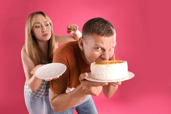 Homem Ganancioso Escondendo Bolo Saboroso Mulher Fundo Rosa — Fotografia de Stock