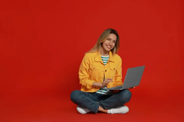 Jeune Femme Avec Ordinateur Portable Moderne Sur Fond Rouge — Photo