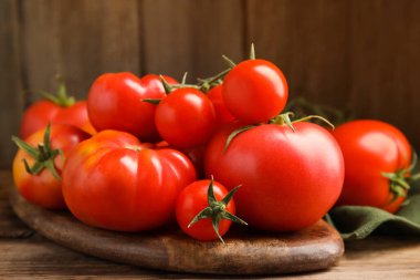 Tahta masadaki farklı olgun domatesler, yakın plan.