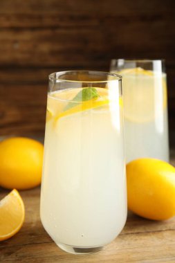 Soğuk taze limonata ve ahşap masada meyveler.