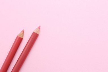 Pembe arka planda dudak kalemi, metin için boşluk. Kozmetik ürünü