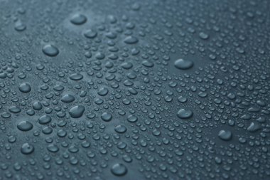 Koyu mavi arka planda birçok su damlası var. Yakın plan.