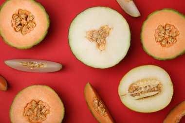 Kırmızı arkaplanda farklı tip kavunları kes, düz yat