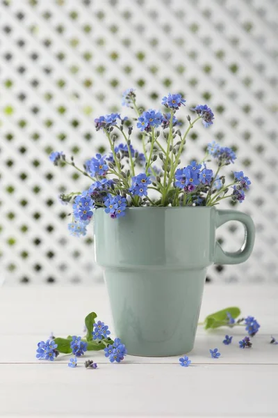 Beautiful blue forget-me-not flowers on white wooden table