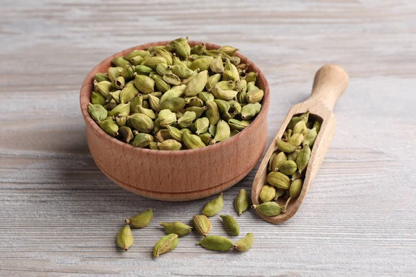 Schüssel Und Schaufel Mit Trockenen Kardamomschoten Auf Holztisch — Stockfoto