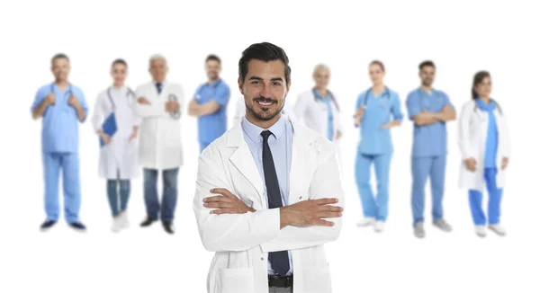 Yakışıklı Genç Doktor Beyaz Arka Planda Bulanık Tıbbi Personel Görüntüsü — Stok fotoğraf