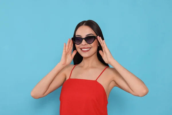 Atractiva Mujer Feliz Tocando Gafas Sol Moda Contra Fondo Azul —  Fotos de Stock