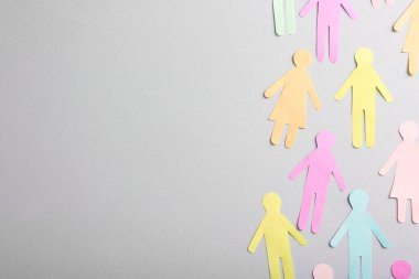 Gri arkaplan üzerinde birçok kağıt insan figürü, metin için boşluk ile düz yatıyordu. Çeşitlilik ve kapsama kavramı