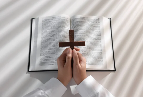 Над Видом Женщины Молящейся Деревянным Крестом Над Библией Белым Столом — стоковое фото