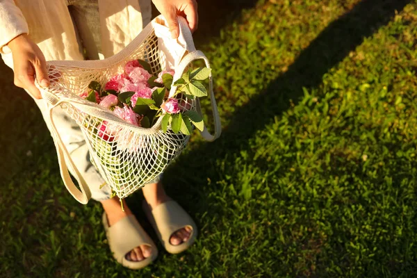 Wanita Memegang Tas Jala Dengan Mawar Teh Indah Luar Ruangan — Stok Foto