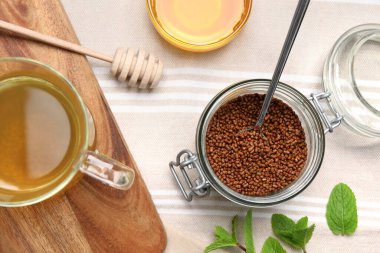 Karabuğday çayı, granüller ve bal masada, düz yerde.