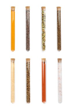 Beyaz zemin üzerinde farklı baharatlar bulunan cam tüpler, üst görünüm