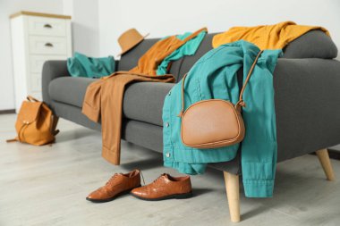 Kanepede kirli giysiler ve oturma odasında ayakkabılar.