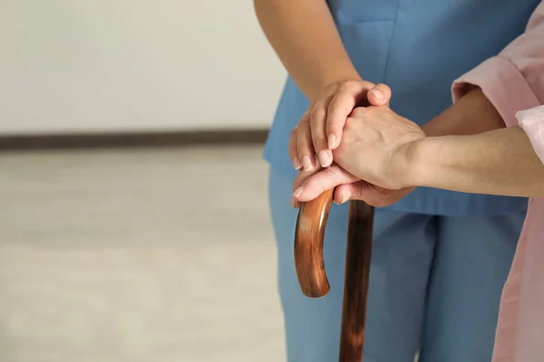 Elderly Woman Walking Cane Female Caregiver Indoors Closeup Space Text —  Fotos de Stock