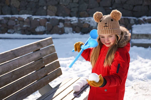 かわいいです女の子遊びますともに雪玉メーカー屋外 — ストック写真
