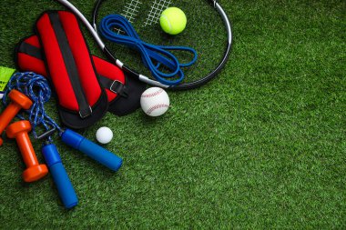 Yeşil çimlerin üzerinde farklı renkte spor aletleri var. Metin için boşluk