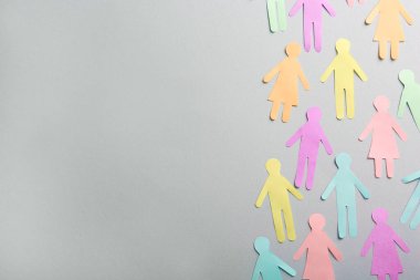 Gri arkaplan üzerinde birçok kağıt insan figürü, metin için boşluk ile düz yatıyordu. Çeşitlilik ve kapsama kavramı