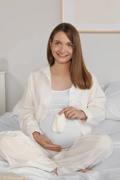 Happy Young Pregnant Woman Baby Socks Bed Home — Stockfoto