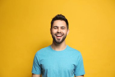 Genç adam sarı arka planda gülüyor. Komik şaka.