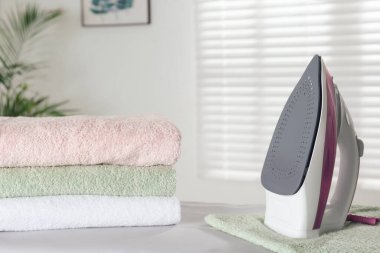Modern iron and clean towels on board indoors