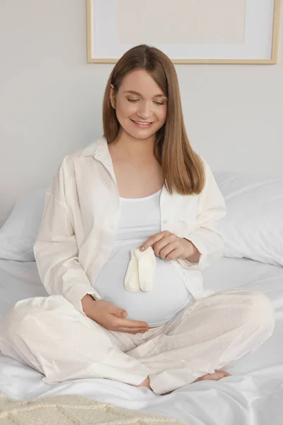Happy Young Pregnant Woman Baby Socks Bed Home — Stockfoto
