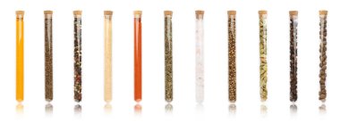 Beyaz zemin üzerinde farklı baharatlar bulunan cam tüpler. Pankart tasarımı