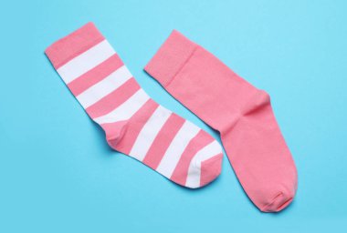 Açık mavi arka planda farklı pembe çoraplar, düz yatış