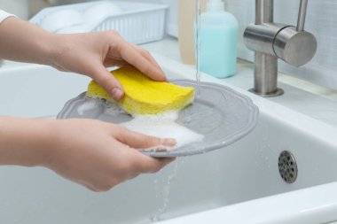 Mutfakta bulaşık yıkayan kadın, yakın çekim.